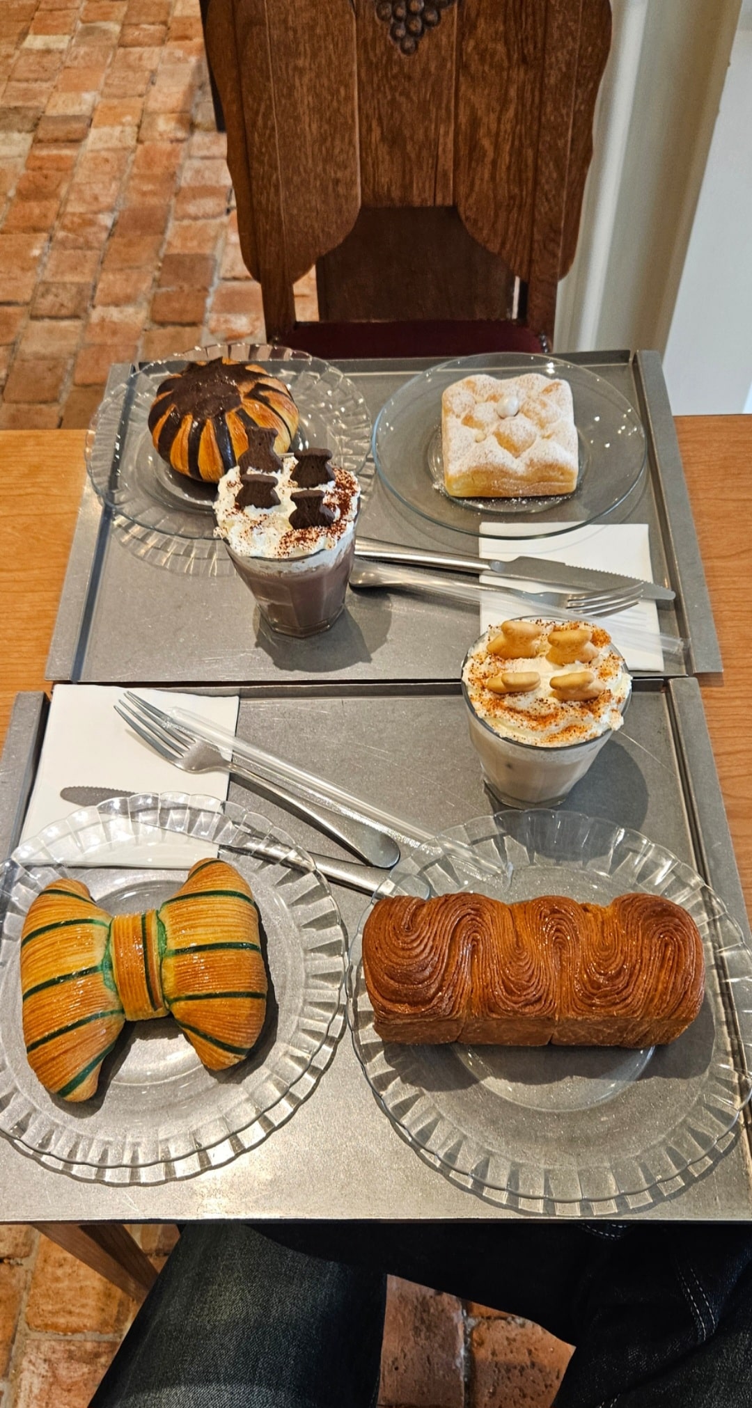 Texte alternatif « Table d'un café coréen avec quatre pâtisseries originales aux formes travaillées et deux boissons crémeuses servies sur des plateaux individuels. C'est le Café MOONI (무니) à Apgujeong en Corée du Sud.